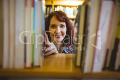 Mature student picking out book in library