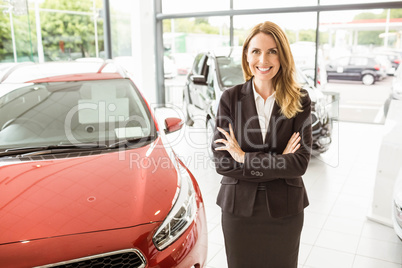 Smiling saleswoman standing with arms crossed