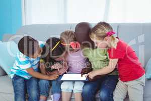 Happy kids using technology while sitting