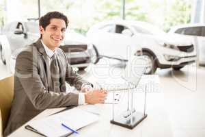 Smiling salesman behind his desk