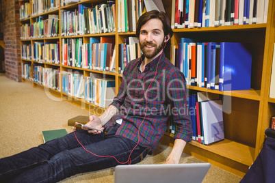 Student using phone in library on floor