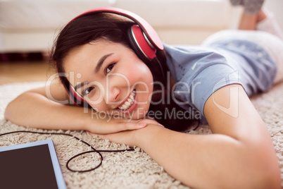 Asian woman using tablet on floor