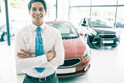 Smiling businessman standing with arms crossed