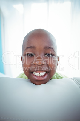 Happy kid looking from the back of the couch