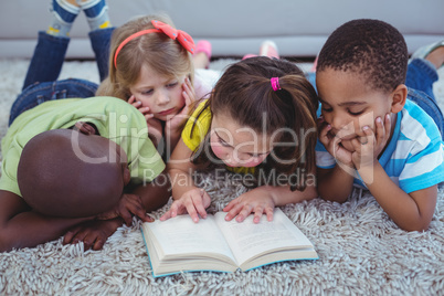 Happy kids reading a book together