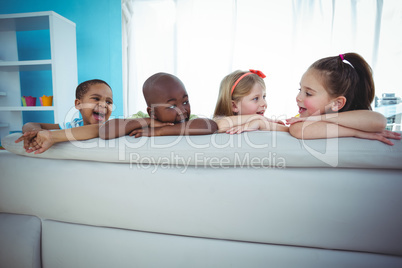 Happy kids looking from the back of the couch