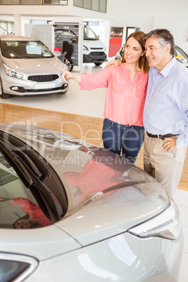 Couple talking together while looking at car