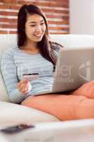 Asian woman on the couch using laptop