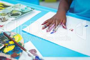 Happy kid enjoying painting with his hands