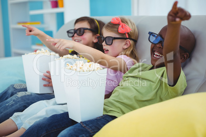 Happy kids sitting together watching a movie