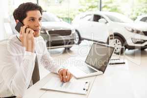 Smiling salesman having a phone call