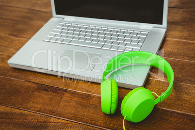 View of a grey laptop with a green headphone