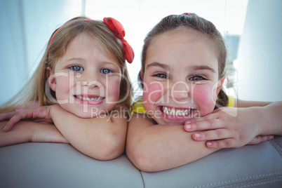 Happy kids looking from the back of the couch