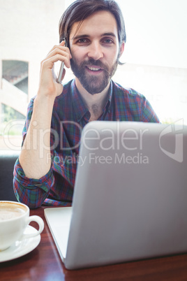 Hipster student using laptop in canteen