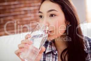 Asian woman on the couch drinking water