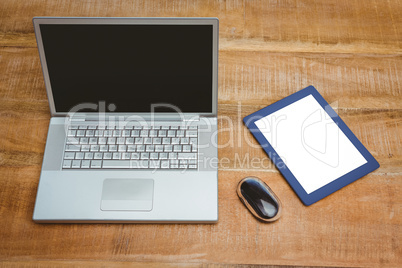 View of a grey laptop with a blue tablet