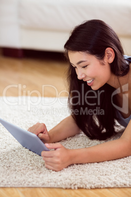 Asian woman using tablet on floor