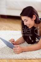 Asian woman using tablet on floor