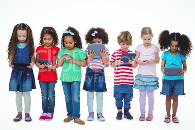 Kids standing together holding tablets and phones