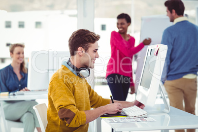 Graphic designer wearing headphones at desk