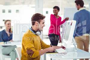 Graphic designer wearing headphones at desk