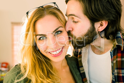 Hipster kissing his pretty colleague