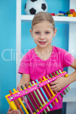 Smiling girl holding a xylophone