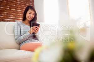 Asian woman reading text on couch