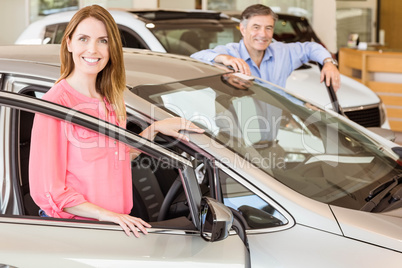 Smiling couple leaning on car