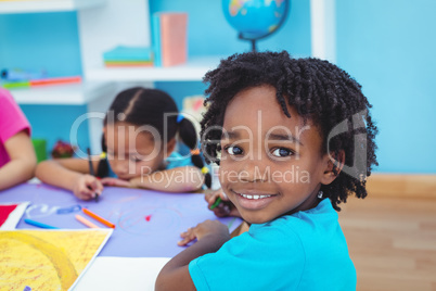 Children drawing on coloured paper