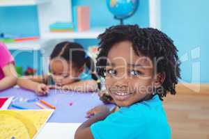 Children drawing on coloured paper