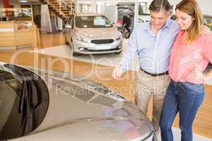 Couple talking together while looking at car