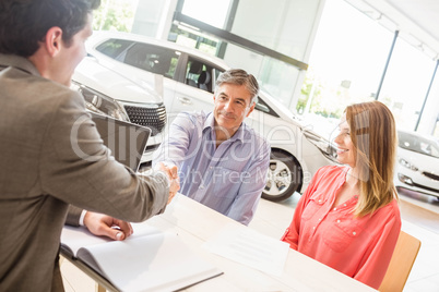 Smiling couple buying a new car