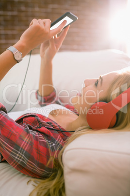 Pretty blonde listening to music on couch