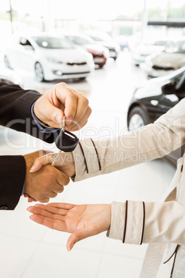 Salesman offering car key to a customers