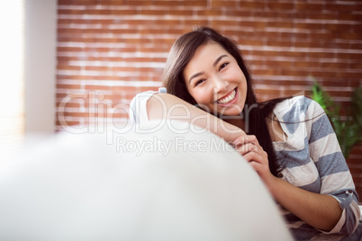 Smiling asian woman on couch