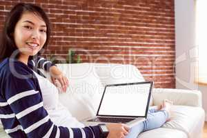 Asian woman on the couch using laptop