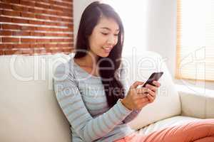 Asian woman reading text on couch