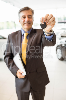 Male driver showing a key after buying a new car