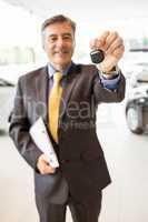 Male driver showing a key after buying a new car