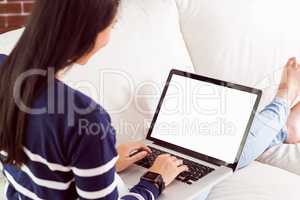 Asian woman on the couch using laptop