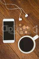 View of a white smartphone with a cup of coffee