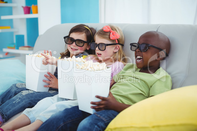 Happy kids sitting together with boxes of popcorn Happy kids sitting together with boxes of popcorn