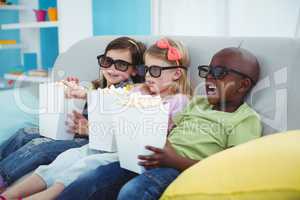 Happy kids sitting together with boxes of popcorn