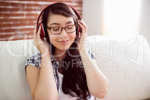 Asian woman on the couch listening to music