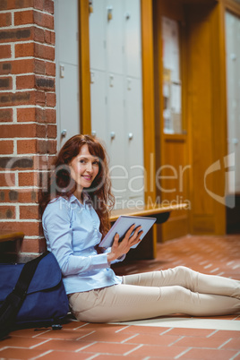 Mature student using tablet in hallway