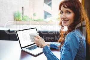 Mature student using laptop in cafe