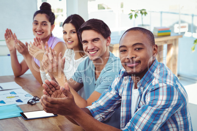 Creative business team applauding at meeting