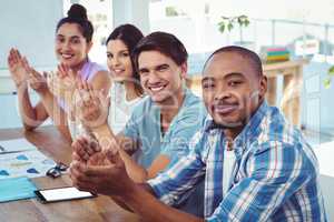 Creative business team applauding at meeting