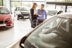 Businesswoman and her client looking at a car